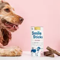 Een hond die glimlacht naast Chicken Smile Sticks