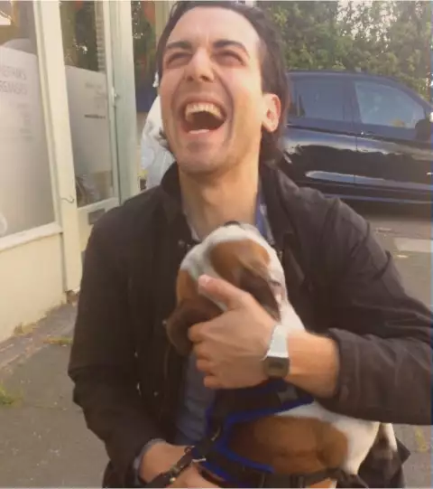Dave hugging a dog looking happy as ever.