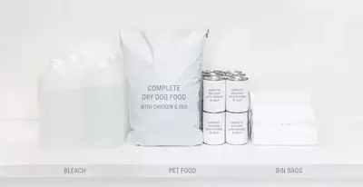 Tierfutter und Haushaltswaren wie Putzmittel und Müllsäcke auf einem weißen Regal.