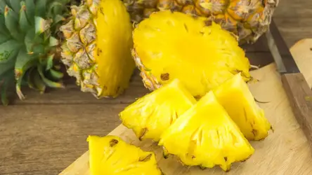 Pokrojony świeży ananas na drewnianej desce.